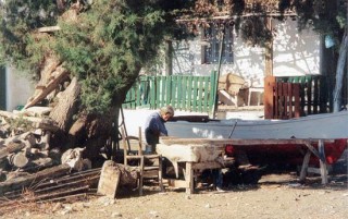 Un vieillard en train de réparer son caïque Un vieillard en train de réparer son caïque